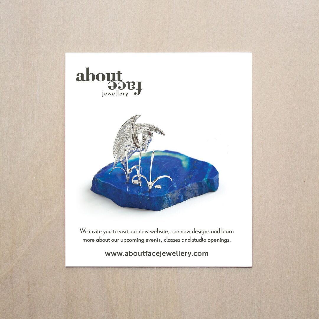 Aboutface Jewellery art card featuring beautiful sculpture of a silver heron wading in lazurite water