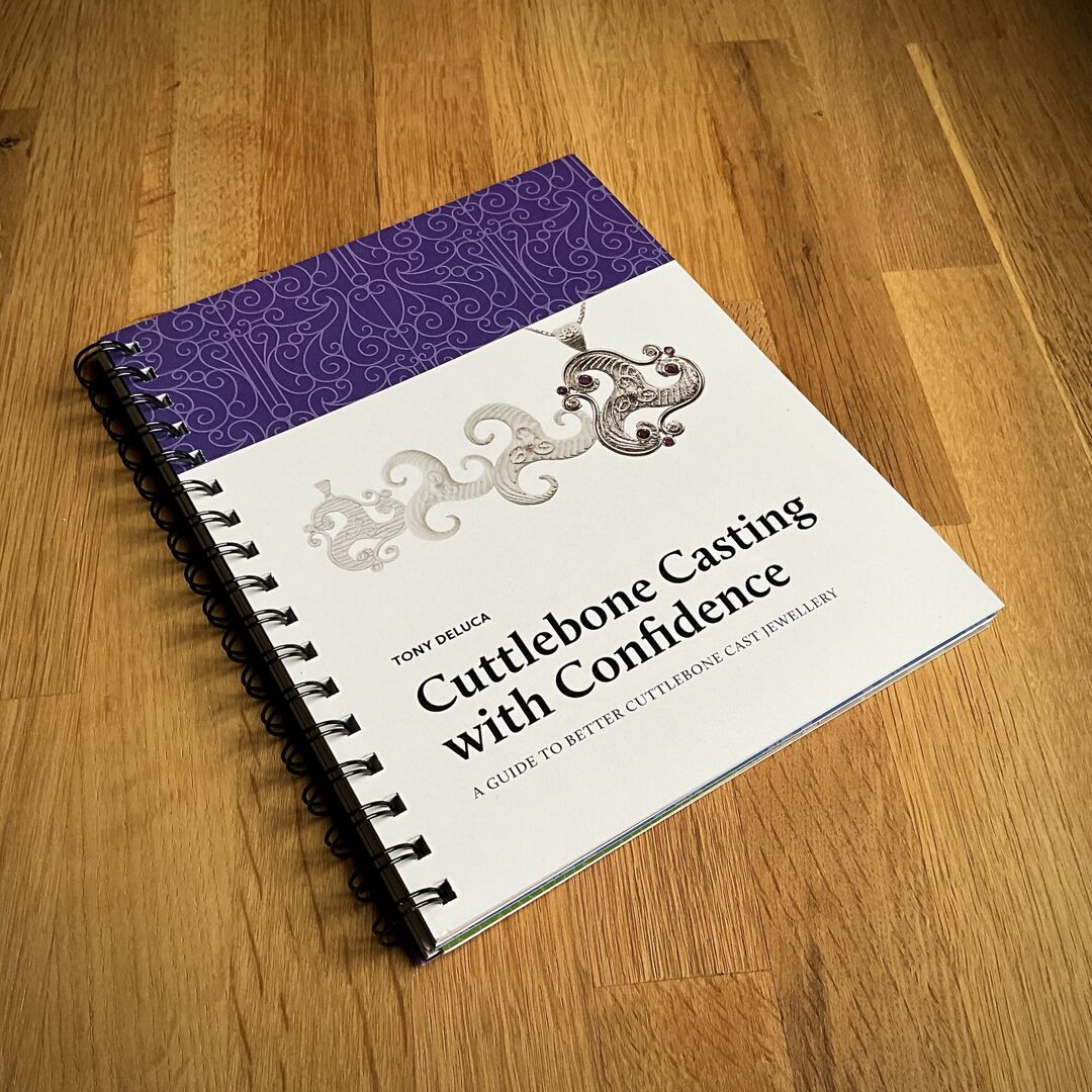 The book "Cuttlebone Casting with Confidence" is placed on a wooden surface.