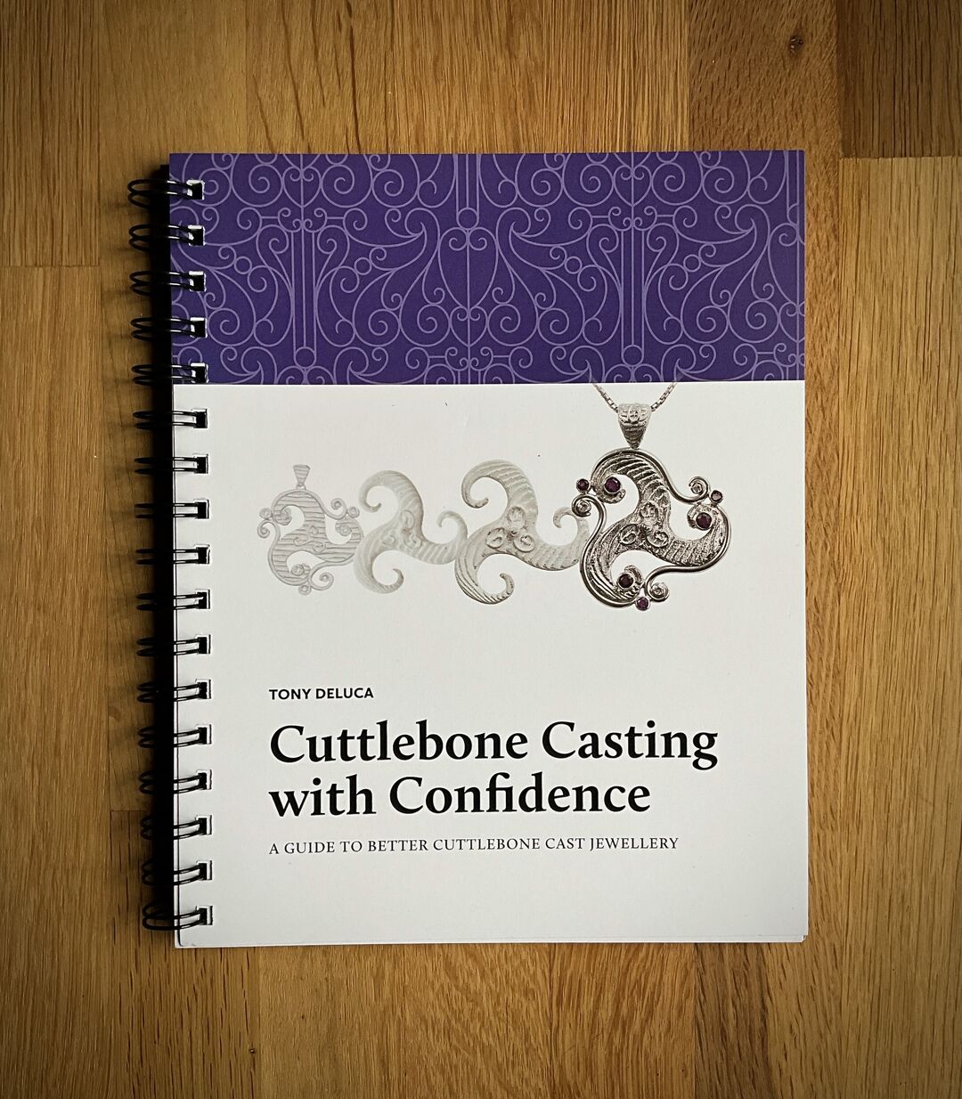 The book cover has a spiral binding and is titled "Cuttlebone Casting with Confidence" by Tony Deluca.